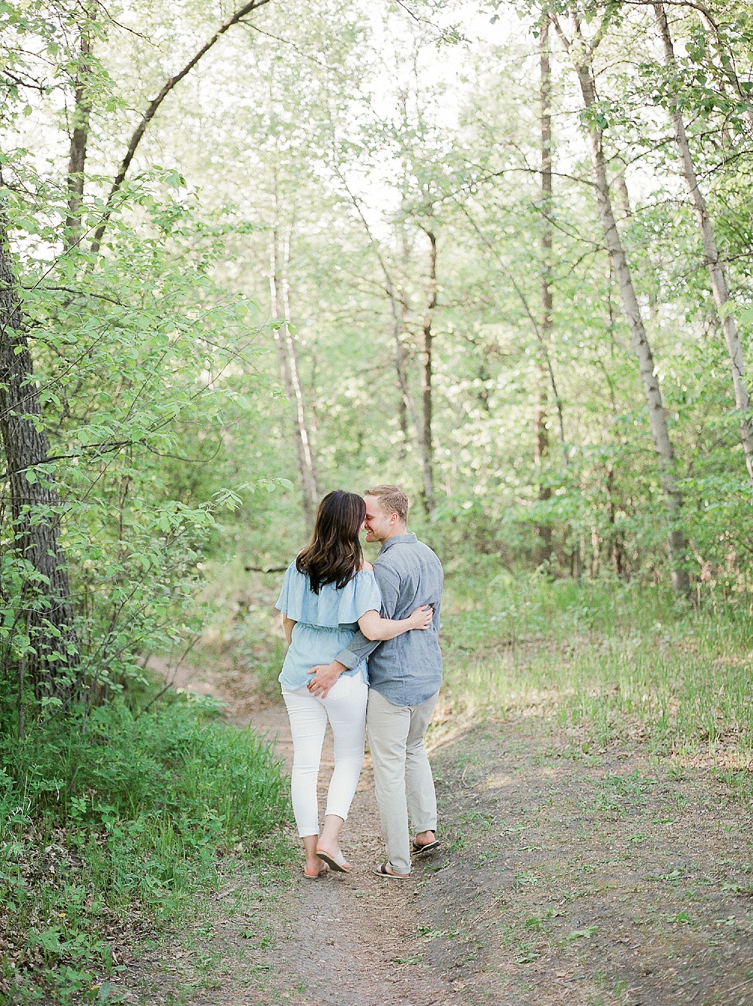 fun engagement photo poses, engagement session outfit ideas for summer, engagement photos at a park, kings park winnipeg, denim over the shoulder top, 
